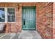 Inviting entryway featuring a stylish green front door, brick surround, and sidelight for a warm welcome at 3109 S Jebel Way, Aurora, CO 80013