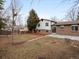 Wide shot of a backyard with a brick house, garden beds and a wood fence creating a private outdoor space at 1643 S Fairplay St, Aurora, CO 80012