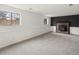 Finished basement area with windows, dark accent wall, and a cozy brick fireplace at 1643 S Fairplay St, Aurora, CO 80012