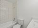 Bright bathroom featuring a tub with white subway tile surround, a white toilet, and a vanity with solid surface countertop at 1643 S Fairplay St, Aurora, CO 80012