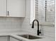 Close up of modern kitchen faucet and stainless steel sink and new countertops in the kitchen at 1643 S Fairplay St, Aurora, CO 80012