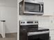 Close up of stainless steel microwave and oven with quartz counters and white subway tile backsplash at 1643 S Fairplay St, Aurora, CO 80012