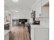 Open kitchen view with stainless steel appliances, white cabinets, and a view to the upstairs living area at 1643 S Fairplay St, Aurora, CO 80012