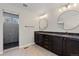 Bathroom boasts and sinks, granite counters, bronze fixtures and tiled shower with glass door at 1815 Avery Way, Castle Rock, CO 80109