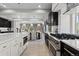 Chef's kitchen boasts a gas range, large island, dark wood cabinets, and views into the open concept living spaces at 1815 Avery Way, Castle Rock, CO 80109