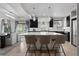 Kitchen featuring island with seating, stainless steel appliances, white marble countertops, dark cabinets, and modern lighting at 1815 Avery Way, Castle Rock, CO 80109