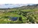 Panoramic aerial perspective featuring a serene pond, lush greenery, golf course, and distant hills at 1006 Homestake Dr # 1D, Golden, CO 80401