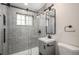 Modern bathroom featuring new lighting, gray wall tiles, and sleek fixtures at 1362 Wolff St, Denver, CO 80204