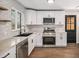 Updated kitchen with stainless appliances, stone countertops, and new white cabinets at 1362 Wolff St, Denver, CO 80204