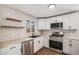 Updated kitchen featuring white cabinetry, floating shelves, and stainless steel appliances at 1362 Wolff St, Denver, CO 80204