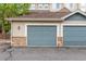 A view of two garages and stone accents at 457 Black Feather Loop # 702, Castle Rock, CO 80104