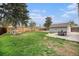 Large, well-manicured backyard with green grass, mature trees, and an outdoor patio area and detached garage at 2272 Jay St, Edgewater, CO 80214