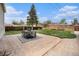Landscaped backyard featuring a stone patio with an outdoor dining set, manicured grass, and wood fence at 2272 Jay St, Edgewater, CO 80214