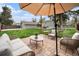 Backyard patio lounge area shaded by a large umbrella, with comfortable seating and a view of the well-maintained yard at 2272 Jay St, Edgewater, CO 80214