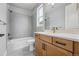 Bathroom featuring a shower and tub combo with gray tiling and wood cabinets at 3370 Backdrop Ct, Castle Rock, CO 80108