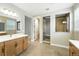 Bathroom featuring a double sink vanity, large mirrors, and an enclosed tiled shower at 3370 Backdrop Ct, Castle Rock, CO 80108