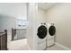 Upper floor laundry room with modern, side-by-side washer and dryer and tiled floor at 3370 Backdrop Ct, Castle Rock, CO 80108