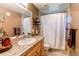 Well-lit bathroom showcasing decorative granite countertops, classic cabinets, and a shower with curtain at 8277 Carriage Ln, Parker, CO 80134