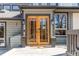 Elegant wooden double doors welcome you to this beautiful home, framed by stylish planters and modern lighting at 8277 Carriage Ln, Parker, CO 80134
