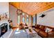 Inviting living room features a vaulted wood ceiling, large windows, and a cozy seating area with modern decor at 8277 Carriage Ln, Parker, CO 80134
