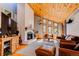 Bright living room with a vaulted wood ceiling, brick fireplace, and large windows for ample natural light at 8277 Carriage Ln, Parker, CO 80134