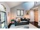 Comfortable living room featuring a decorative stained glass window, hardwood floors and a grey sofa at 8277 Carriage Ln, Parker, CO 80134