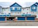 Townhome exteriors featuring a blue and gray color scheme with attached garages at 1372 S Cathay Ct # 104, Aurora, CO 80017