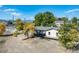 An aerial shot highlights the home's setting, deck, mature trees, and adjacent street at 6365 W Coal Mine Ave, Littleton, CO 80123