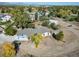 A beautiful aerial view shows the large lot with home, barn, mature trees, and neighborhood at 6365 W Coal Mine Ave, Littleton, CO 80123