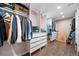 Walk-in closet providing ample storage with custom shelving, drawers, and hanging space on wood floor at 6365 W Coal Mine Ave, Littleton, CO 80123