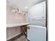 Laundry room with stacked washer and dryer, folding counter, and shelving for storage at 6365 W Coal Mine Ave, Littleton, CO 80123