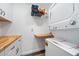 Functional laundry room features white cabinets, butcher block folding counter, and appliances at 6365 W Coal Mine Ave, Littleton, CO 80123