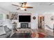 Inviting living room featuring a unique brick fireplace with wood-burning stove and ceiling fan at 6365 W Coal Mine Ave, Littleton, CO 80123