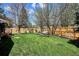 Backyard features wooden fence, grassy yard and mature trees providing shade and privacy at 15357 Flowergate Way, Parker, CO 80134