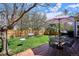 Backyard features wooden deck, dining table and chairs, shade umbrella, and grassy yard at 15357 Flowergate Way, Parker, CO 80134