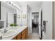 Bathroom with double sinks and a large mirror leading into the bedroom at 15357 Flowergate Way, Parker, CO 80134