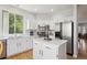Bright kitchen features white cabinets, stainless steel appliances and an island at 15357 Flowergate Way, Parker, CO 80134