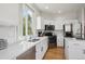 Bright kitchen features white cabinets and stainless steel appliances at 15357 Flowergate Way, Parker, CO 80134