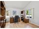 Home office with wooden desk, built-in bookshelves, and natural light from two windows at 15357 Flowergate Way, Parker, CO 80134