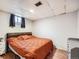 Bright basement bedroom with an orange comforter and wood floors at 9235 Quitman St, Westminster, CO 80031