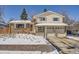 Brick house with two-car garage and snow-covered yard at 9235 Quitman St, Westminster, CO 80031