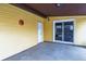 Covered porch with a concrete slab floor and yellow siding with sliding glass doors and a back door at 3052 S Joplin Ct, Aurora, CO 80013