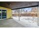 Covered back porch with a concrete slab, a sliding glass door, and a view of the snowy backyard at 3052 S Joplin Ct, Aurora, CO 80013