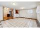 Bright basement with an open area featuring tile flooring and adjoining dining space with warm cabinetry at 3052 S Joplin Ct, Aurora, CO 80013