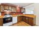 Well-lit kitchen featuring brick accent wall, neutral countertops, and classic wood cabinetry; practical and inviting at 3052 S Joplin Ct, Aurora, CO 80013