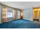 Cozy living room with blue carpet, striped wallpaper, a front door and window with view of snow outside at 3052 S Joplin Ct, Aurora, CO 80013