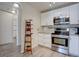 Modern kitchen with stainless steel appliances and white cabinets and drawers on light colored wood floor at 625 S Clinton St # 6B, Denver, CO 80247