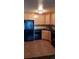 Kitchen featuring wood cabinetry, black appliances, tile floors, and ample counter space at 1977 S Josephine St # 101, Denver, CO 80210