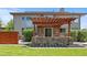 Backyard featuring a stone patio with pergola, lush green grass, and mature landscaping at 14325 N Santa Fe St, Broomfield, CO 80023
