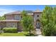 Elegant two-story home featuring a stone facade, tile roof, and lush landscaping at 14325 N Santa Fe St, Broomfield, CO 80023